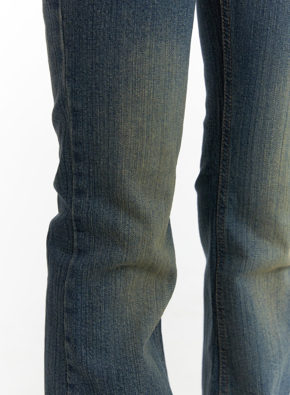 Washed Flared Jeans CM413 in blue, macro close-up of knee-to-hem area, showing washed denim texture, vertical fading, and flared bootcut seam detail.