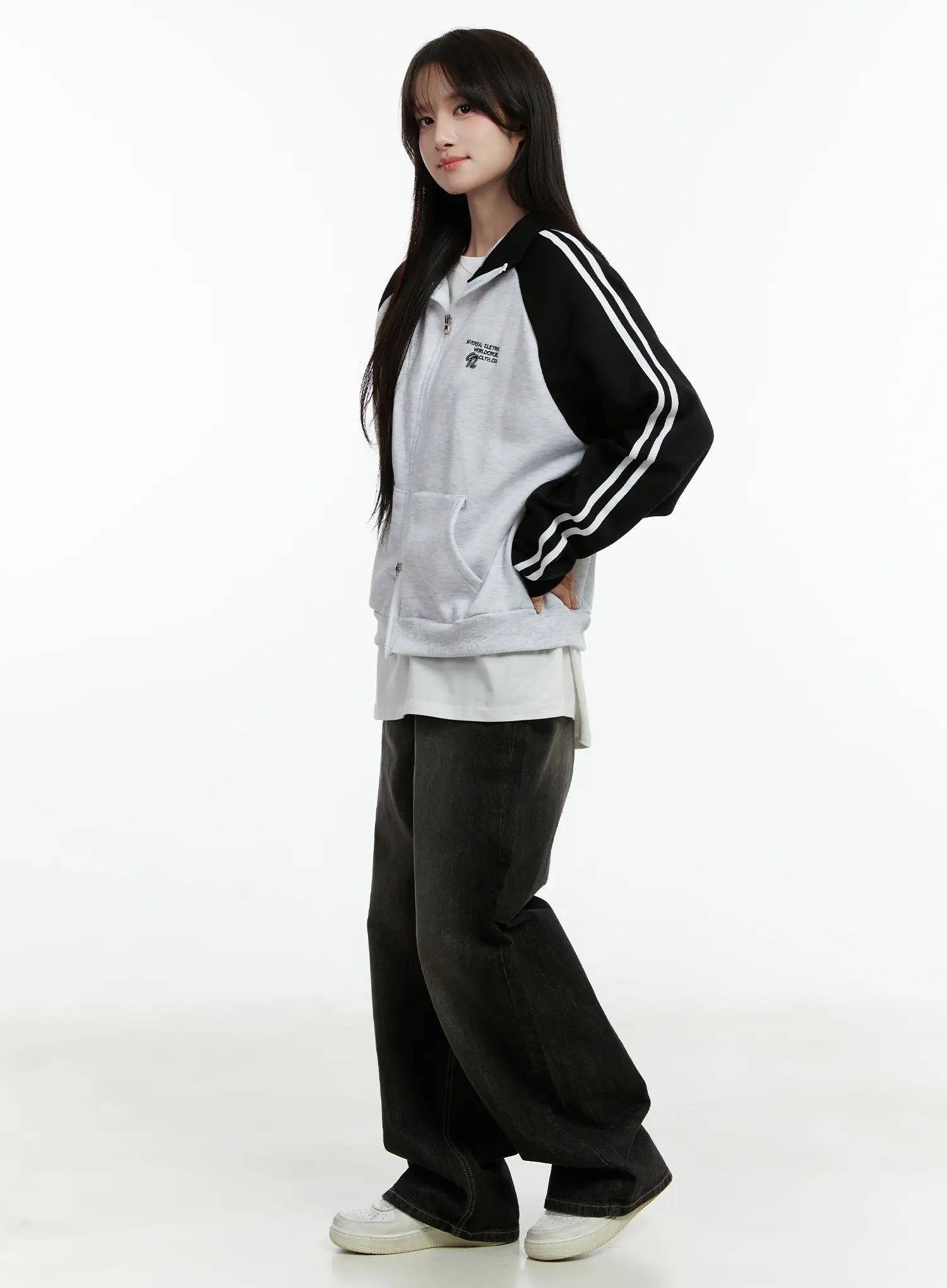 Haze Washed Wide-Leg Jeans CD523 in black, three-quarter side shot on model, relaxed wide-leg length with floor-grazing hem, paired with sporty zip-up hoodie.