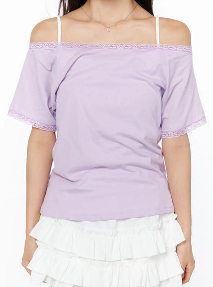 Lace Trim Off-Shoulder Tee CU522 in light purple, close-up front torso shot on model, lace trim along off-shoulder neckline and sleeve hem clearly visible, cotton fabric, paired with white ruffle skirt.