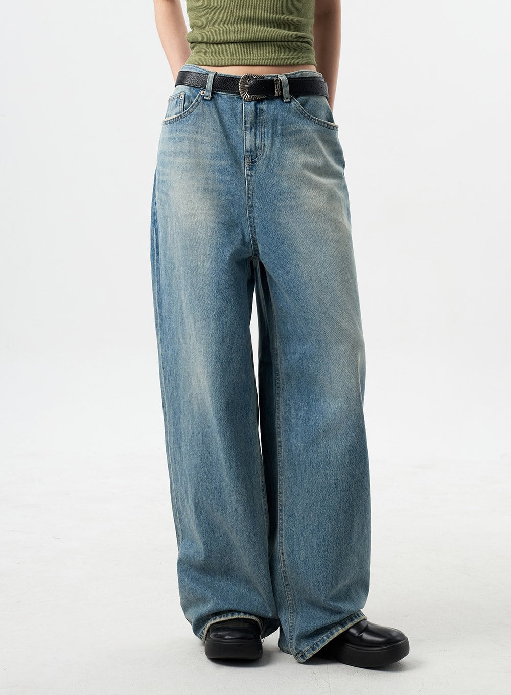 Oversized Jeans Unisex CY312 in washed blue, side-angled waist-to-hem shot on model, wide-leg denim with faded wash showing volume through thigh, black western belt.