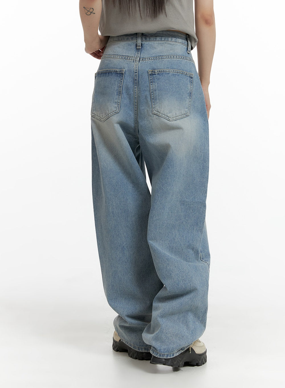 Wide Leg Baggy Jeans CM405 in light blue wash, back view on model, showing two back patch pockets, washed denim finish, and relaxed wide-fit silhouette with chunky sneakers.