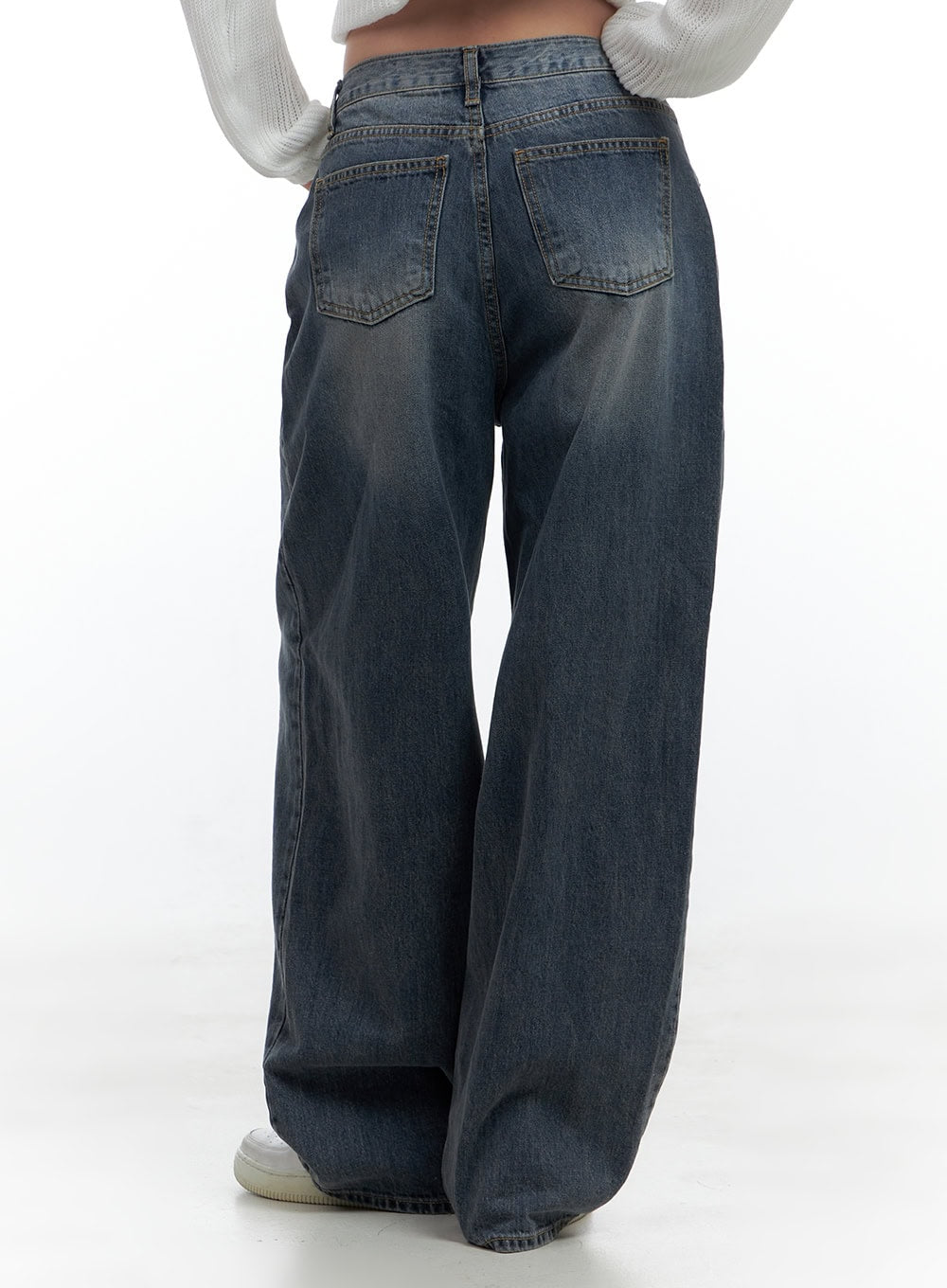 Lana Oversized Wide-Leg Jeans CS425 in blue, back waist-to-hem view on model, washed cotton denim with two back patch pockets and faded wash detail, ultra-wide leg, paired with white knit crop top.