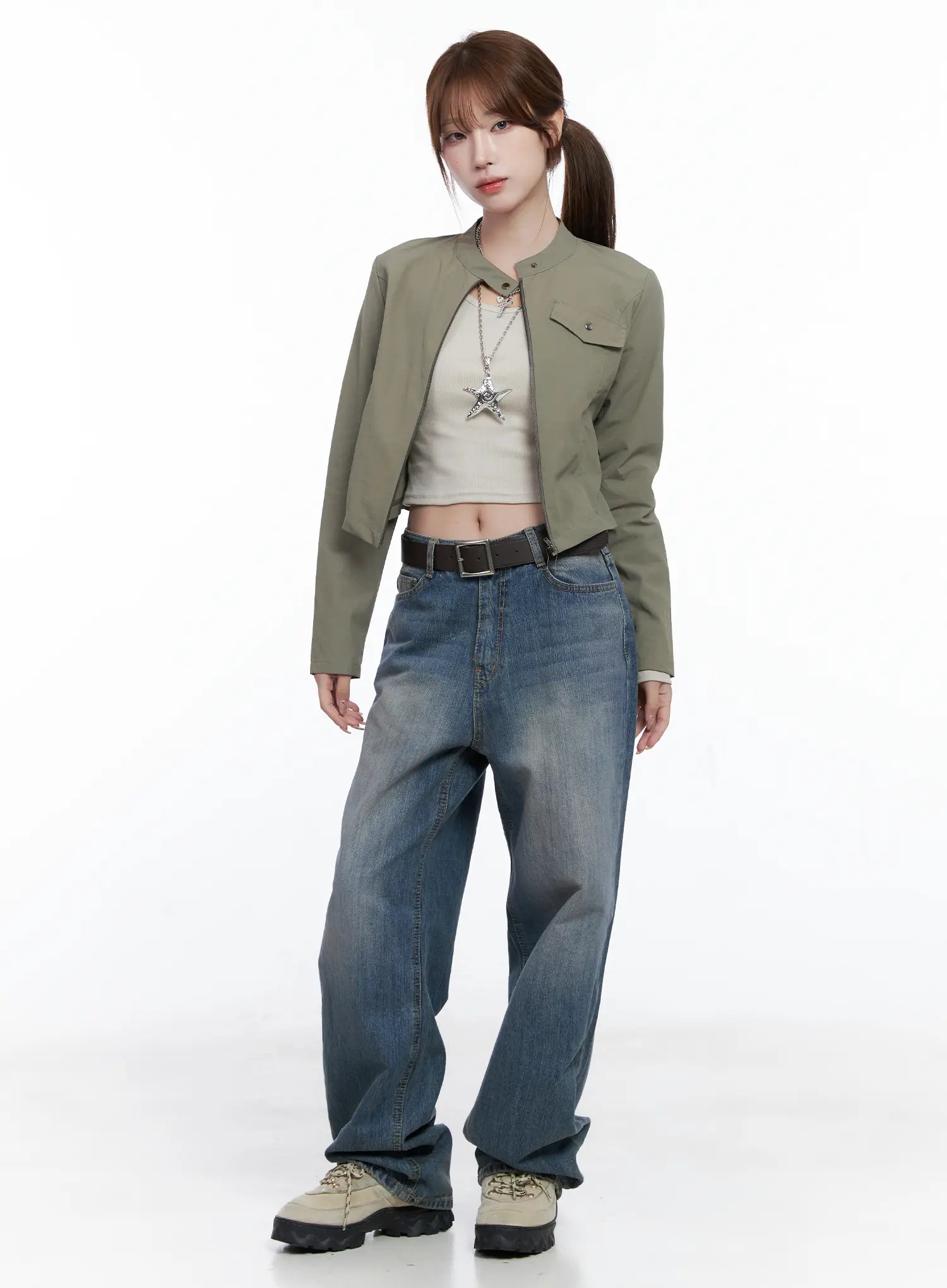 Lala Wide Leg Vintage Washed Jeans CG529 in blue, full-body front shot on model, paired with olive crop jacket, beige crop top, brown belt, and chunky sneakers, street style look.