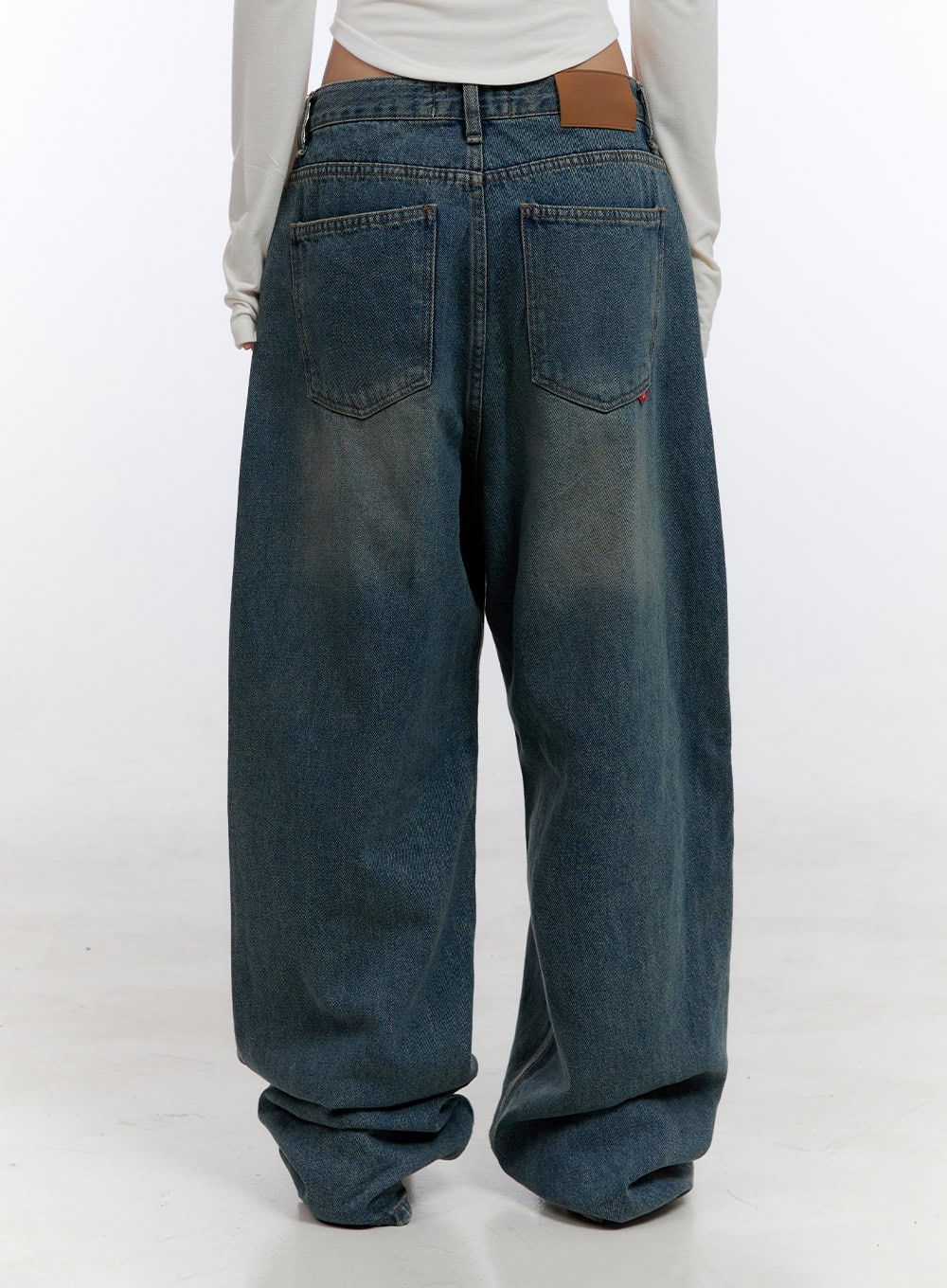Zola Casual Fit Denim Jeans CO422 in blue, back close-up on model, washed cotton denim with dual back pockets, tan leather patch, subtle whiskering, and pooling wide leg hem.