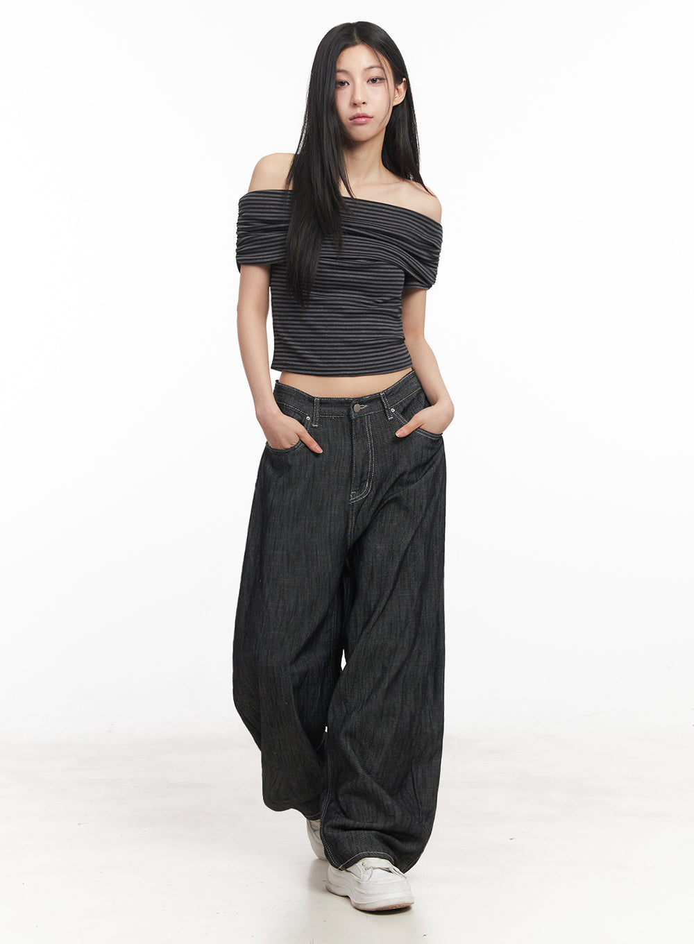 Lilli Wide-Leg Baggy Jeans IY516 in Black, full-body front shot on model, hands in pockets, low-rise wide-leg baggy denim paired with striped off-shoulder crop top and white sneakers.