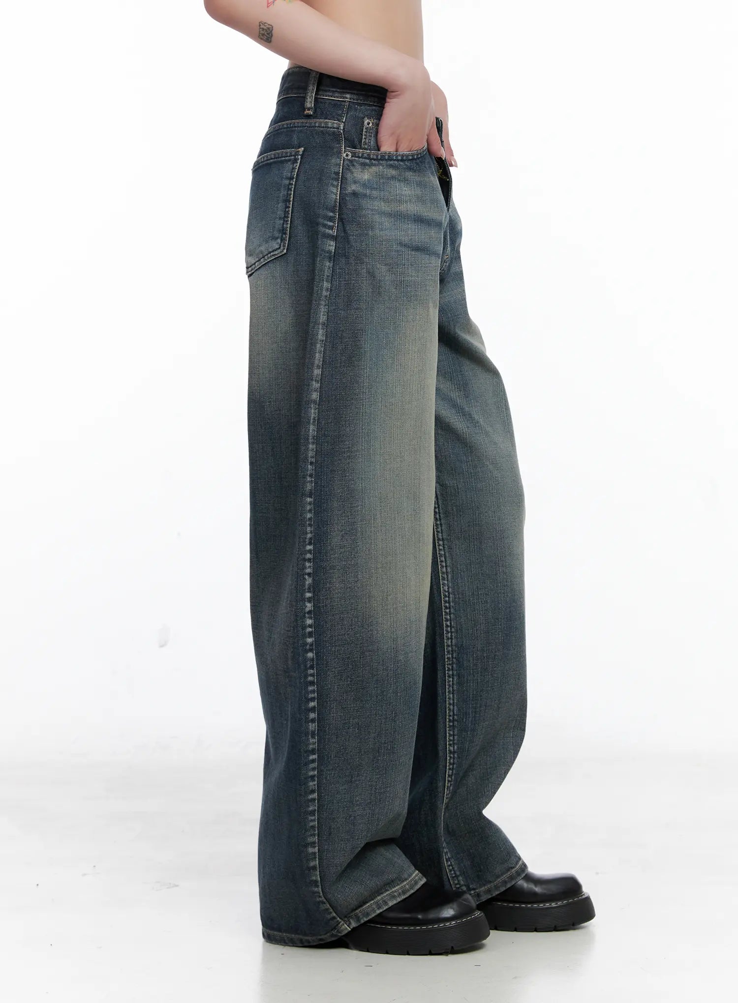 Nellie Baggy Jeans CS526 in blue, side close-up on model, highlighting low-rise waistband, side seam, and heavily washed cotton fabric with faded whisker detail.