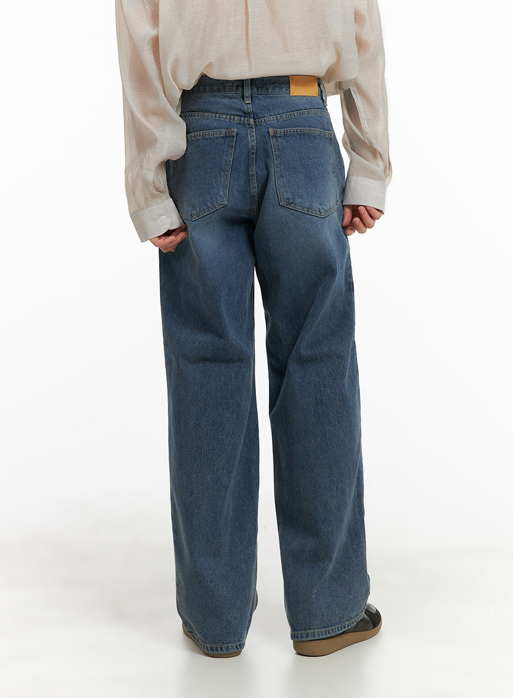 Men's Washed Denim Wide Fit Jeans IA402 in blue, back view on model, featuring two back pockets and leather patch label, wide leg regular length, paired with sheer cream shirt.