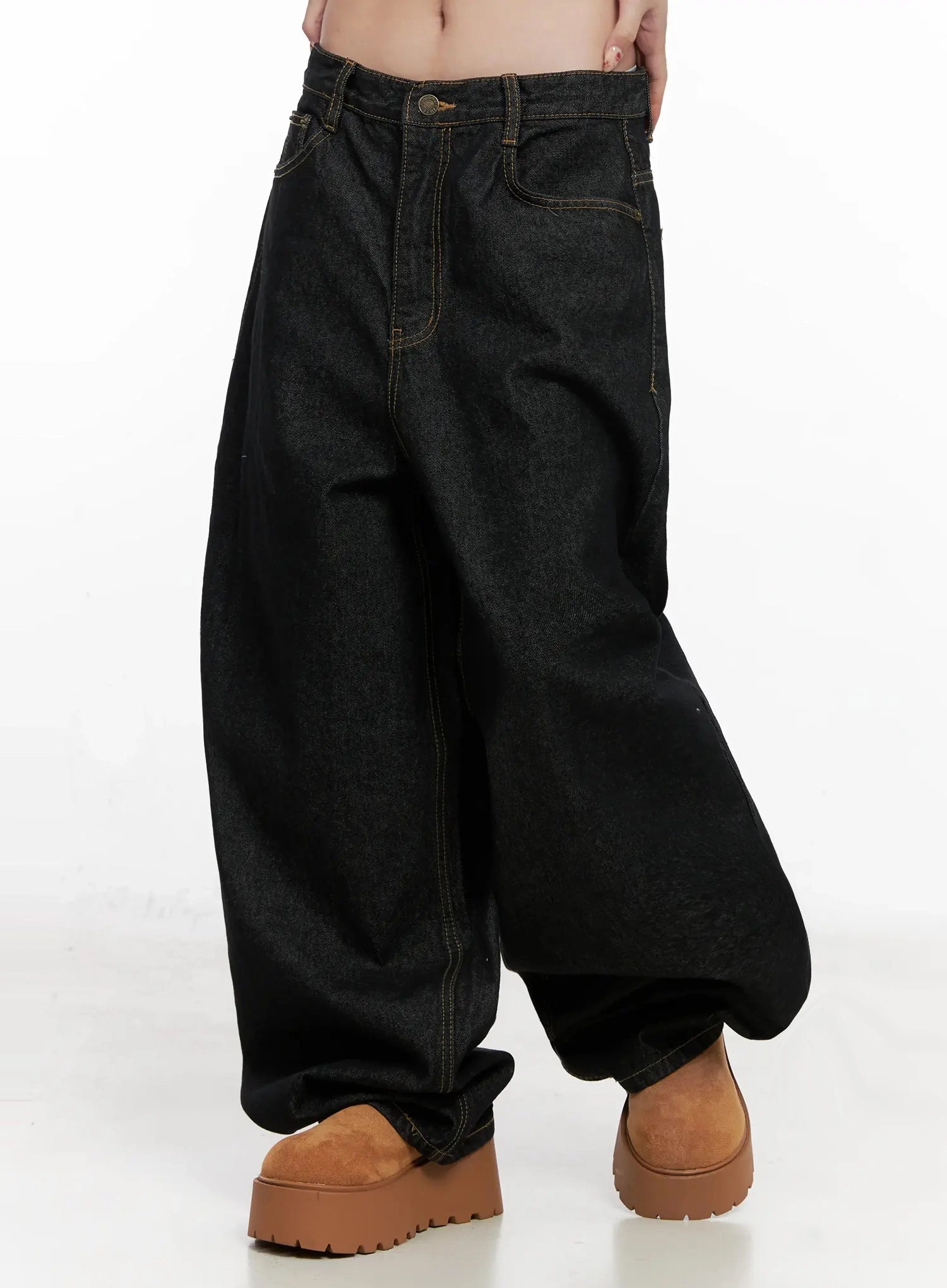 Halo Wide Leg Stitch Detail Jeans IN514 in black, side-angled waist-down shot on model, exaggerated wide-leg volume and curved seam with gold topstitch detail, worn with tan platform sneakers.