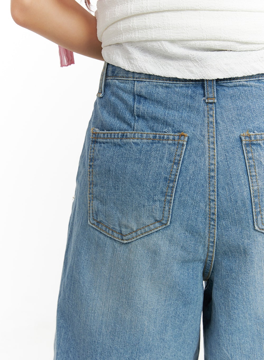 Washed Wide Leg Jorts CA409 in blue, close-up back pocket detail on model, dual patch pockets with gold topstitching, washed denim texture visible.