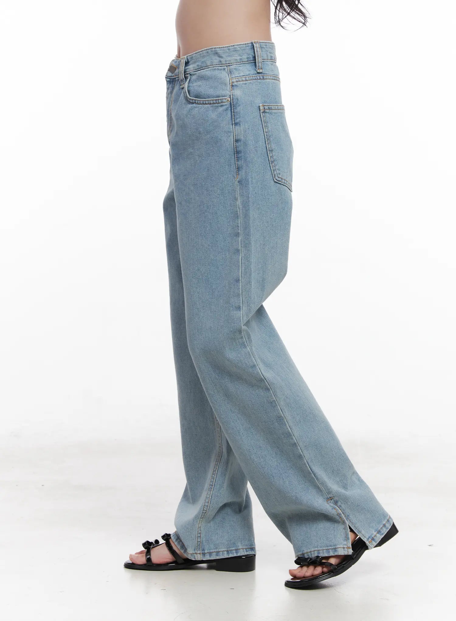 Hyuna Slit Straight-Fit Jeans CU525 in light blue, side view on model from waist down, wide-fit washed denim with straight leg silhouette, rear pocket and hem slit visible.