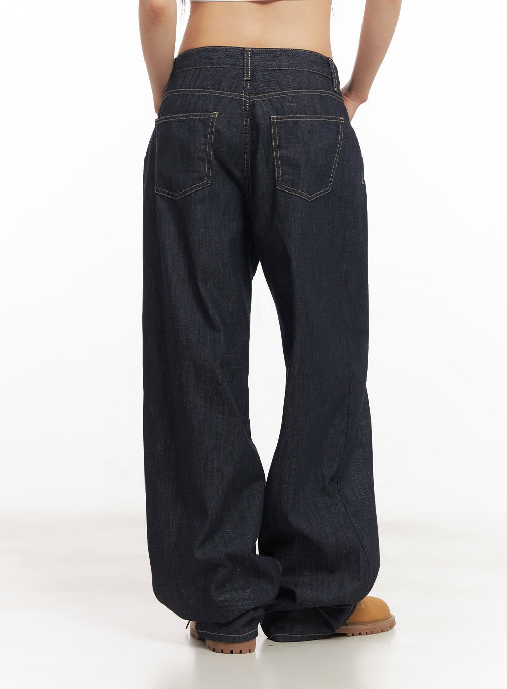 Ivara Wide-Leg Jeans CA522 in dark blue, back view on model, showing dual back pockets with contrast topstitching, wide-leg silhouette pooling at hem, paired with tan boots.