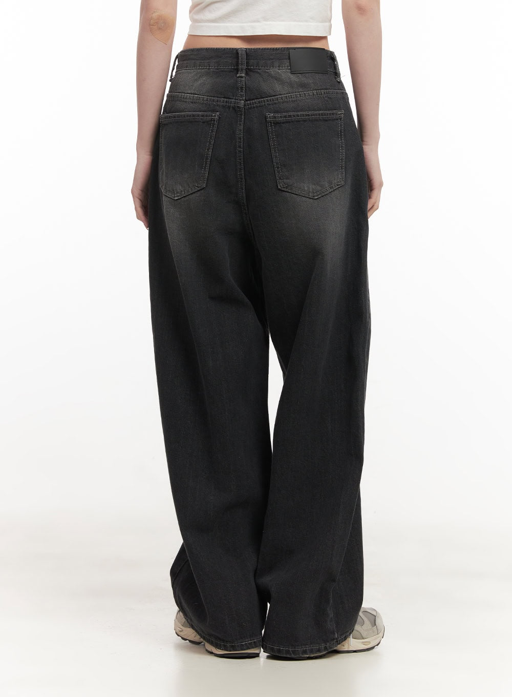 Ruth Washed Wide-Leg Jeans CF514 in black, straight back view close-up on model, dual back pockets with contrast stitching, washed black cotton denim, sneakers at hem.