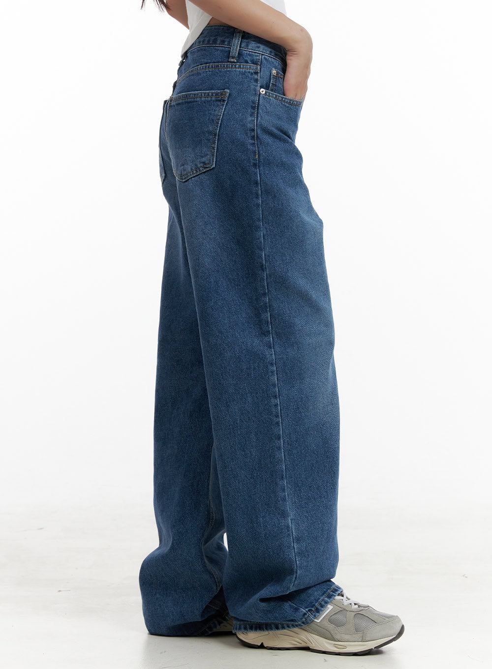 Eva Blue Washed Baggy Jeans CL431 in blue, side detail close-up on model from waist to hem, highlighting wide baggy leg and back pocket, washed denim texture visible, with grey sneakers.