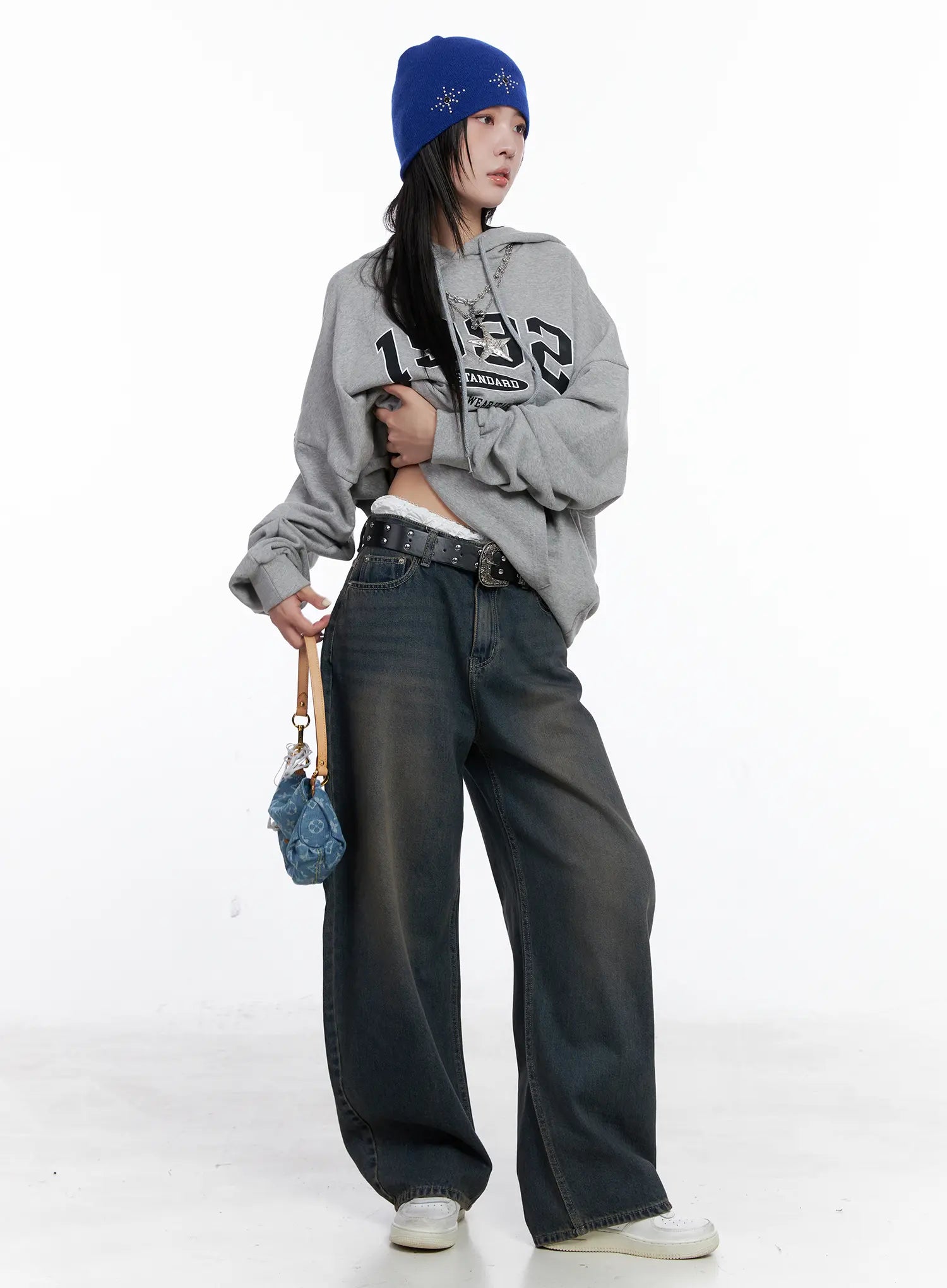 Ocean Faded Balloon Fit Jeans CS510 in washed dark indigo, three-quarter front shot on model, street style outfit with grey graphic hoodie, blue beanie, and mini denim bag.