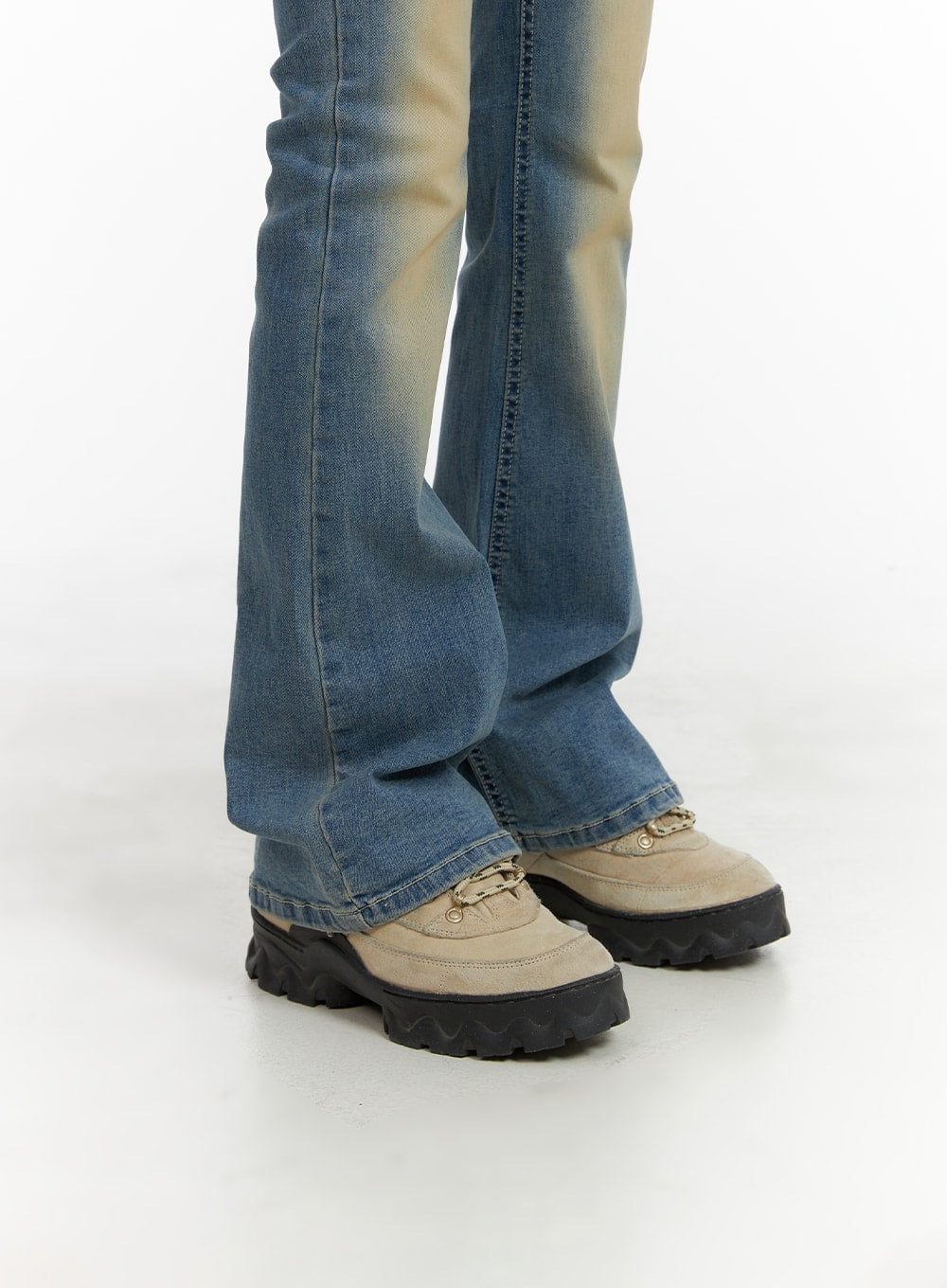 Slim Fit Washed Bootcut Jeans CA402 in blue, hem and bootcut flare close-up on model, washed denim flare grazing chunky tan lug-sole boots, slight fading gradient toward the ankle.