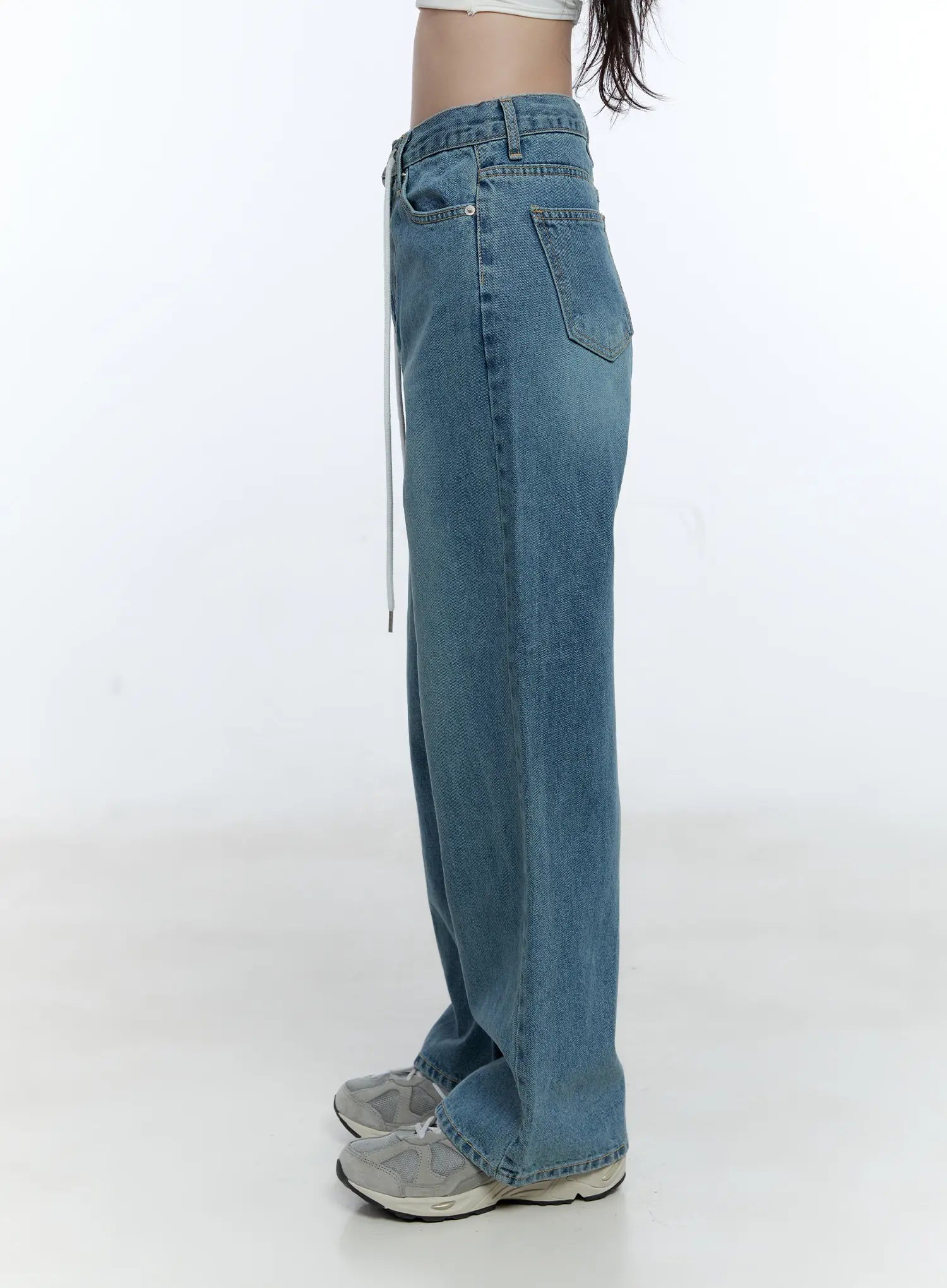 High-Waist Wide-Leg Drawstring Jeans CG513 in blue, close-up side shot on model, highlighting high-waist fit, side pocket, white drawstring detail, and washed cotton texture.