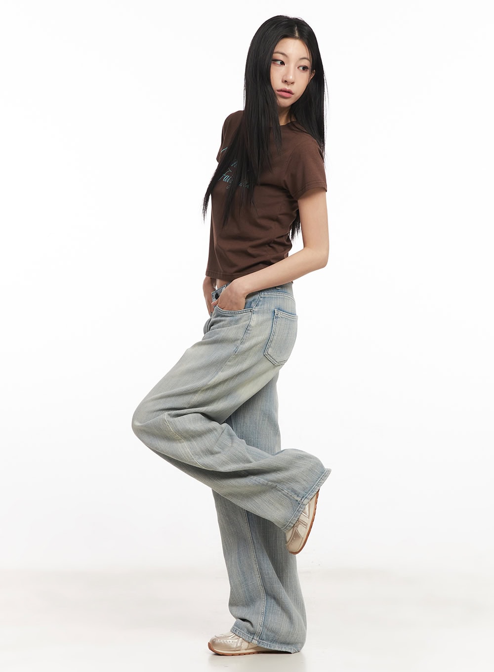 Jessi Washed Wide-Leg Jeans CA514 in light blue, side editorial shot on model with one leg raised, wide-leg washed denim showing leg drape and volume, with brown crop tee.