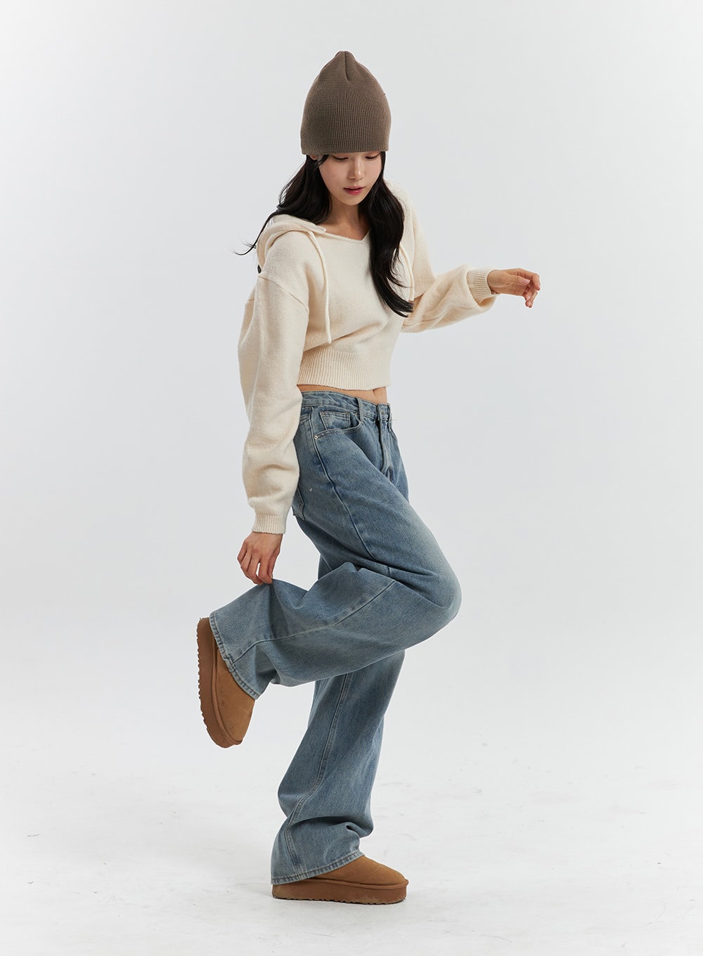 Mid Waist Washed Button Wide Leg Jeans OD320 in blue, full-body dynamic pose on model with one leg raised, showcasing wide-leg drape and washed denim movement, paired with cream crop hoodie.