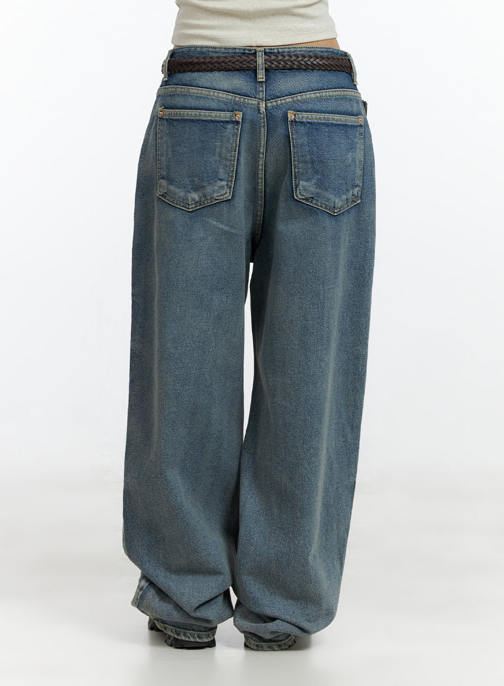 Dark Washed Baggy Jeans CL410 in blue, back view close-up on model, wide-fit low-rise denim showing dual back patch pockets, washed cotton fabric, and braided belt at waistband.