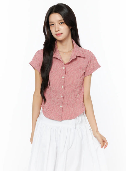 Gingham Button-Up Short Sleeve Blouse CU522 in red, front view on model standing straight, cropped waist-length fit, cuffed sleeves, paired with white tiered skirt.