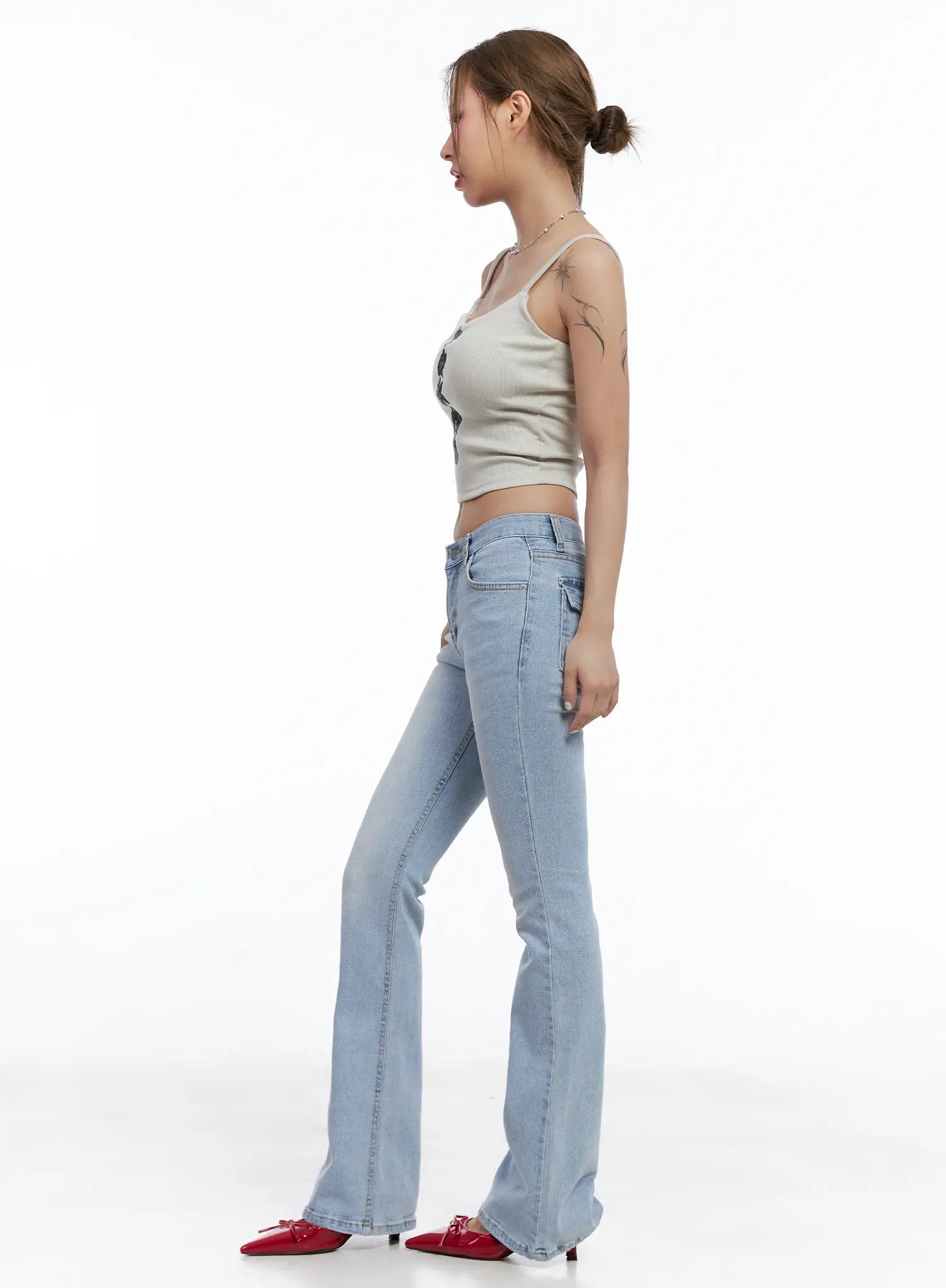 Yeojin Classic Flare Denim Jeans CL510 in light blue, side profile full-length shot on model, flare leg and low rise waistband visible, styled with beige cami top and red heels.