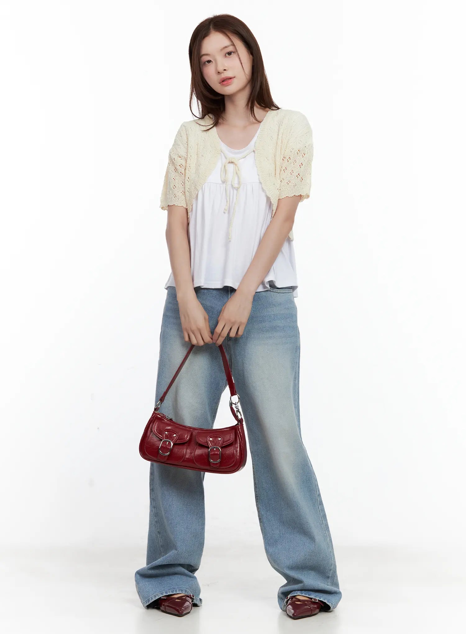 Ina Slouchy Fit Jeans CL502 in blue, full-body front shot on model holding red shoulder bag, loose wide-leg washed denim, styled with cream knit shrug and white smock top, casual street look.