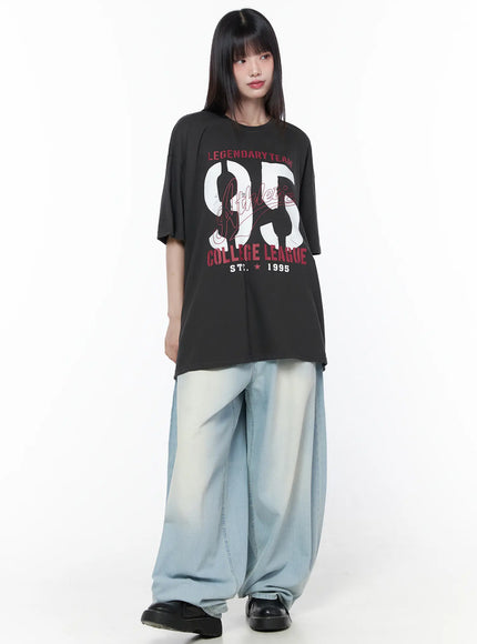 Ozzy Washed Wide Leg Jeans CU519 in light blue, three-quarter front view, styled with oversized graphic tee, voluminous washed denim pooling at hem.
