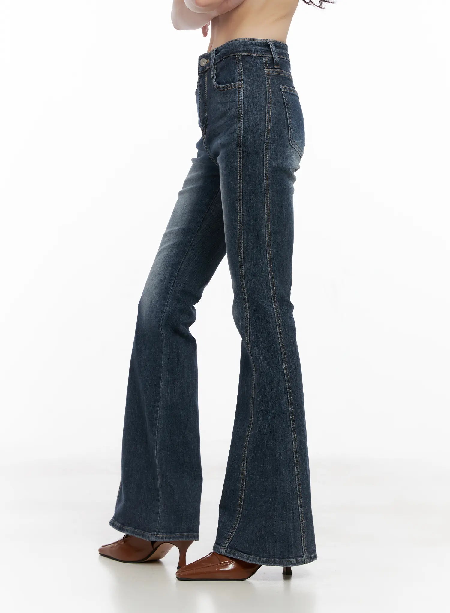 Giana High Waist Hip Pad Flare Jeans CG519 in blue, side full-length view on model, showing slim thigh and flared bootcut leg silhouette with raw hem, brown heels.