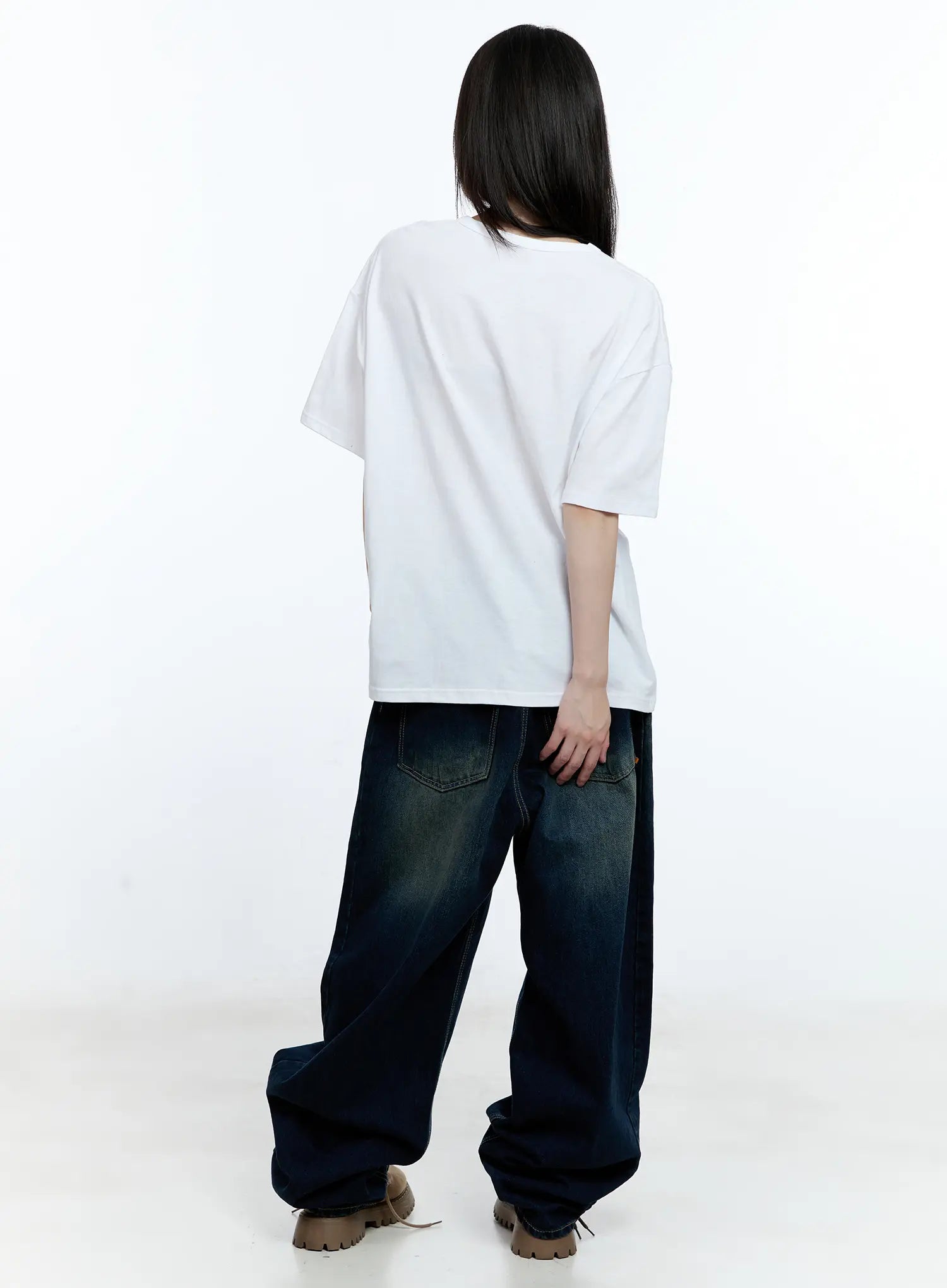 Jinnie Washed Wide-Leg Jeans CG511 in dark blue, back full-body view on model, showing back patch pockets with contrast stitching, wide-leg hem pooling over tan boots, paired with white tee.
