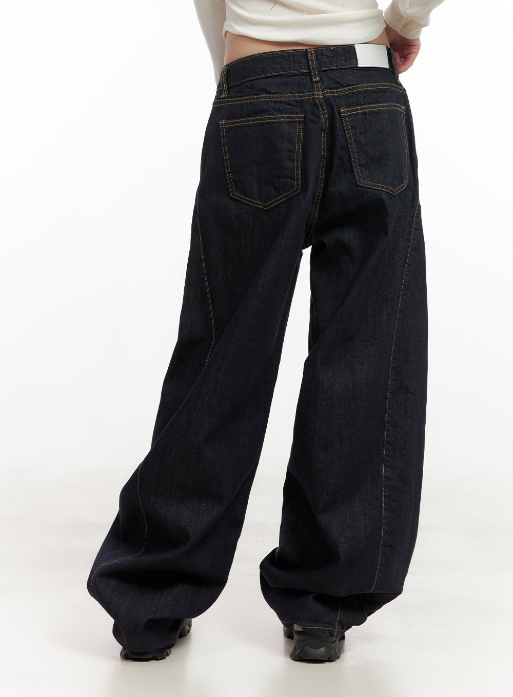 Fernanda Balloon-Fit Baggy Jeans CJ502 in dark blue, back close-up on model, low-waist cotton denim with contrast topstitching, two back patch pockets, and voluminous balloon leg pooling at floor.
