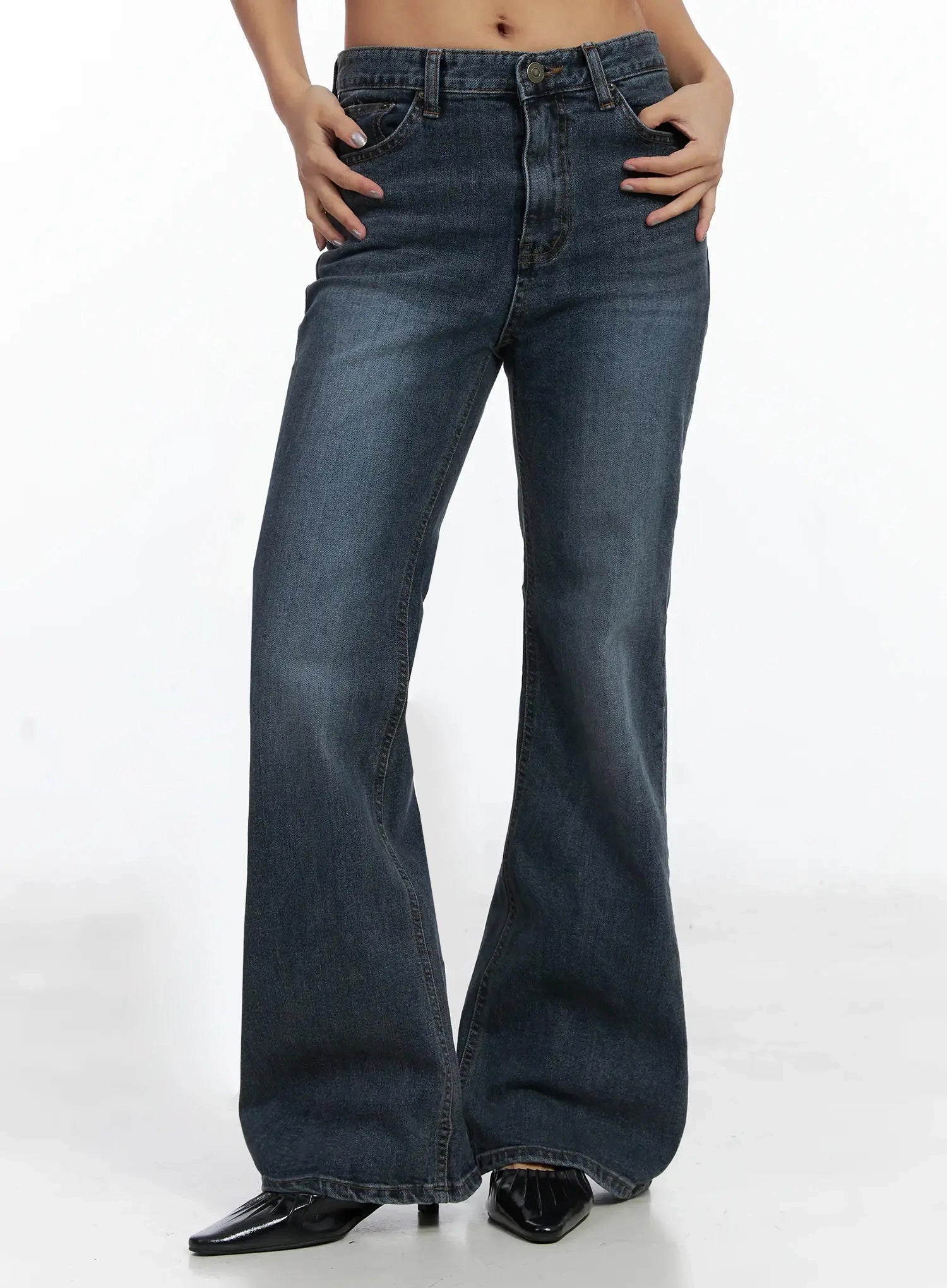 Rara Fleece Flared Jeans ID503 in blue, front mid-body view on model with hands on hips, highlighting washed denim bootcut flare and five-pocket construction with mid-rise fit.