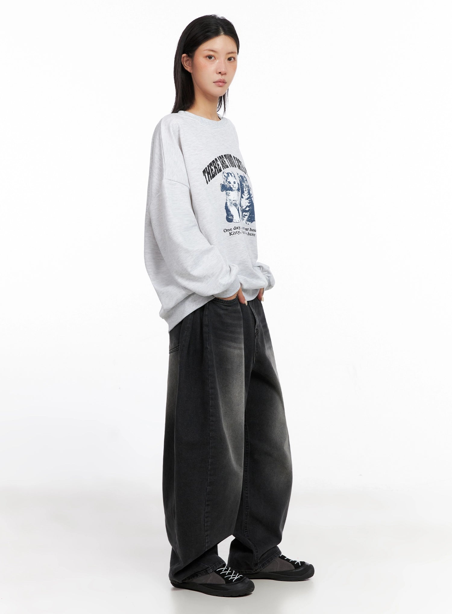 Ayra Dark Washed Baggy Jeans IS508 in dark grey, three-quarter side view on model, wide-fit washed cotton denim with voluminous leg, styled with oversized grey graphic sweatshirt and chunky sneakers.