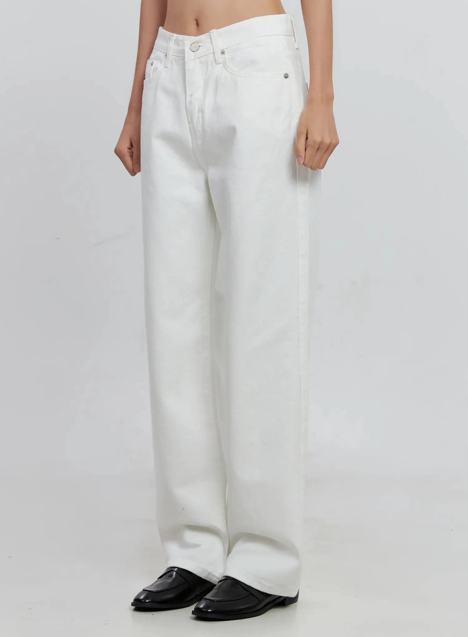 Taytum Straight-Leg Jeans IS515 in white, front angled close-up on model, low-rise straight-leg cotton denim highlighting asymmetric waistband and side seam detail.