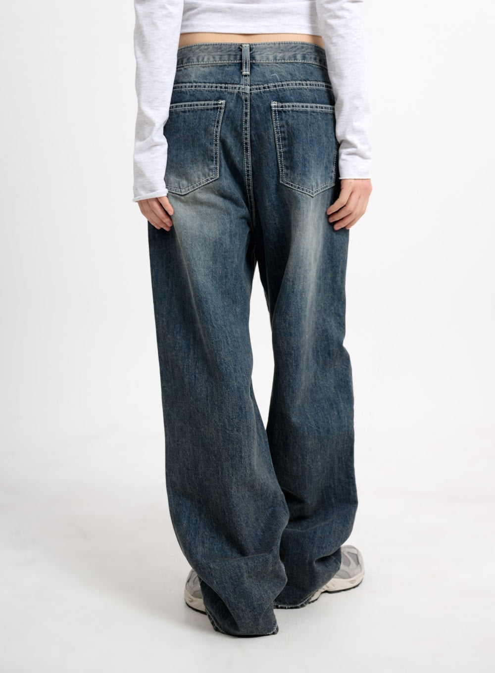 Low Waist Baggy Jeans CM415 in dark blue, back view on model, showing back yoke, patch pockets, centre seam, and washed fading across wide baggy legs.
