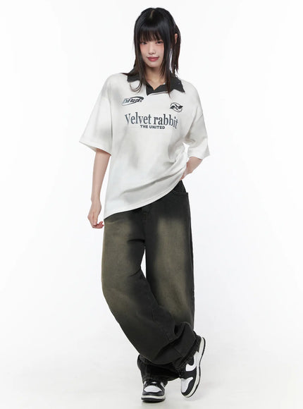 Bodie Vintage Wash Wide Leg Jeans CU519 in black, front full-body on model, relaxed standing pose, styled with oversized graphic polo tee and sneakers, khaki fade-wash denim.
