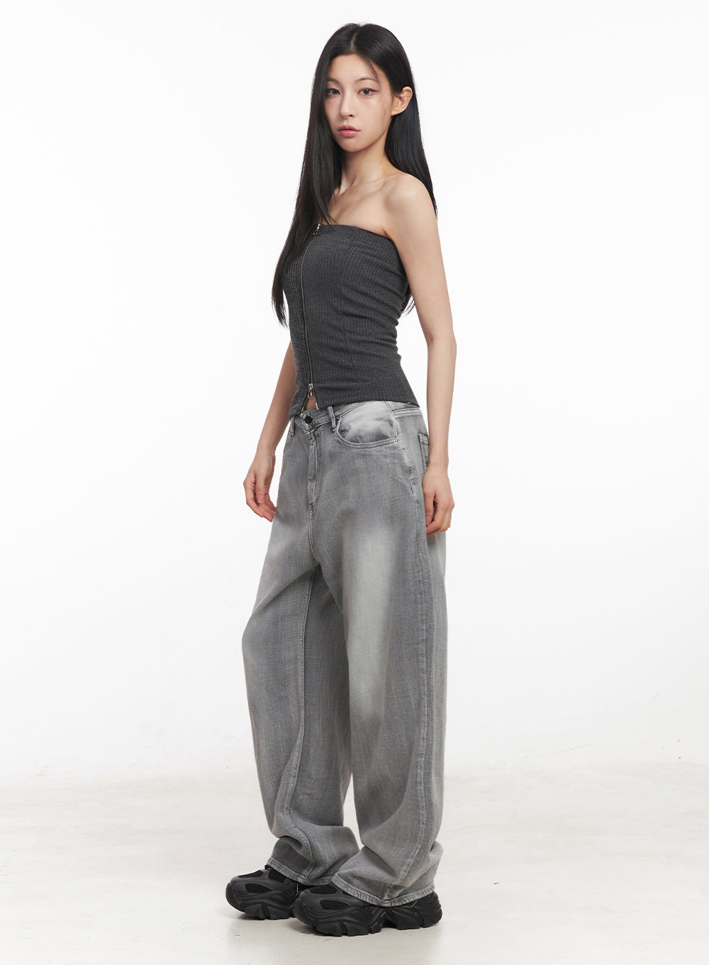 Flore Washed Wide-Leg Jeans IY516 in gray, side view on model, wide-leg silhouette with washed fading visible along leg, paired with dark tube top and chunky sneakers.