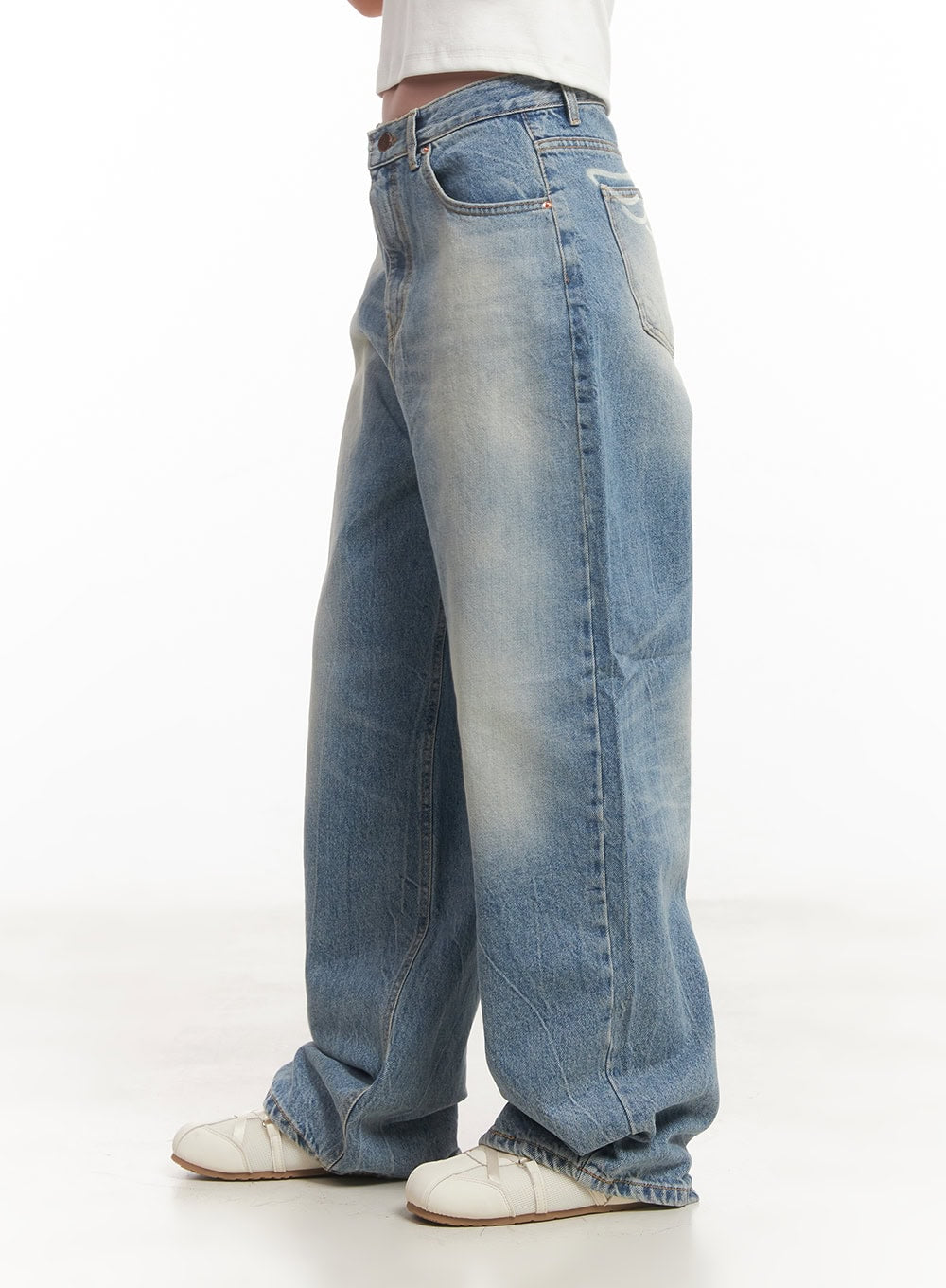 Lumira Back-Detail Washed Wide Leg Jeans CA530 in blue, close-up side shot waist-down on model, washed denim with sun-faded thigh panels, voluminous wide leg pooling at sneakers.