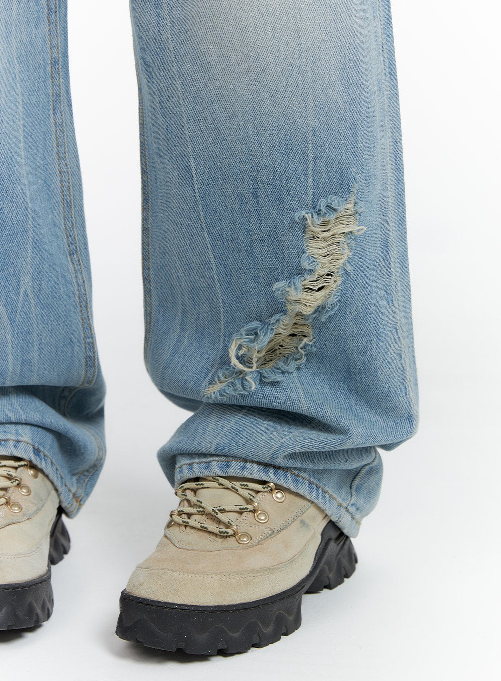 Distressed Wide-leg Jeans CF419 in light blue, lower leg close-up showing hem-area destroyed rip with heavy fraying, petite length pooling over chunky lace-up hiking sneakers.