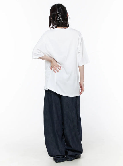 Casual Graphic Short Sleeve Top CU519 in White, back full-body view on model, clean plain back with slightly elongated hem, styled with wide-leg dark denim and hair clips.
