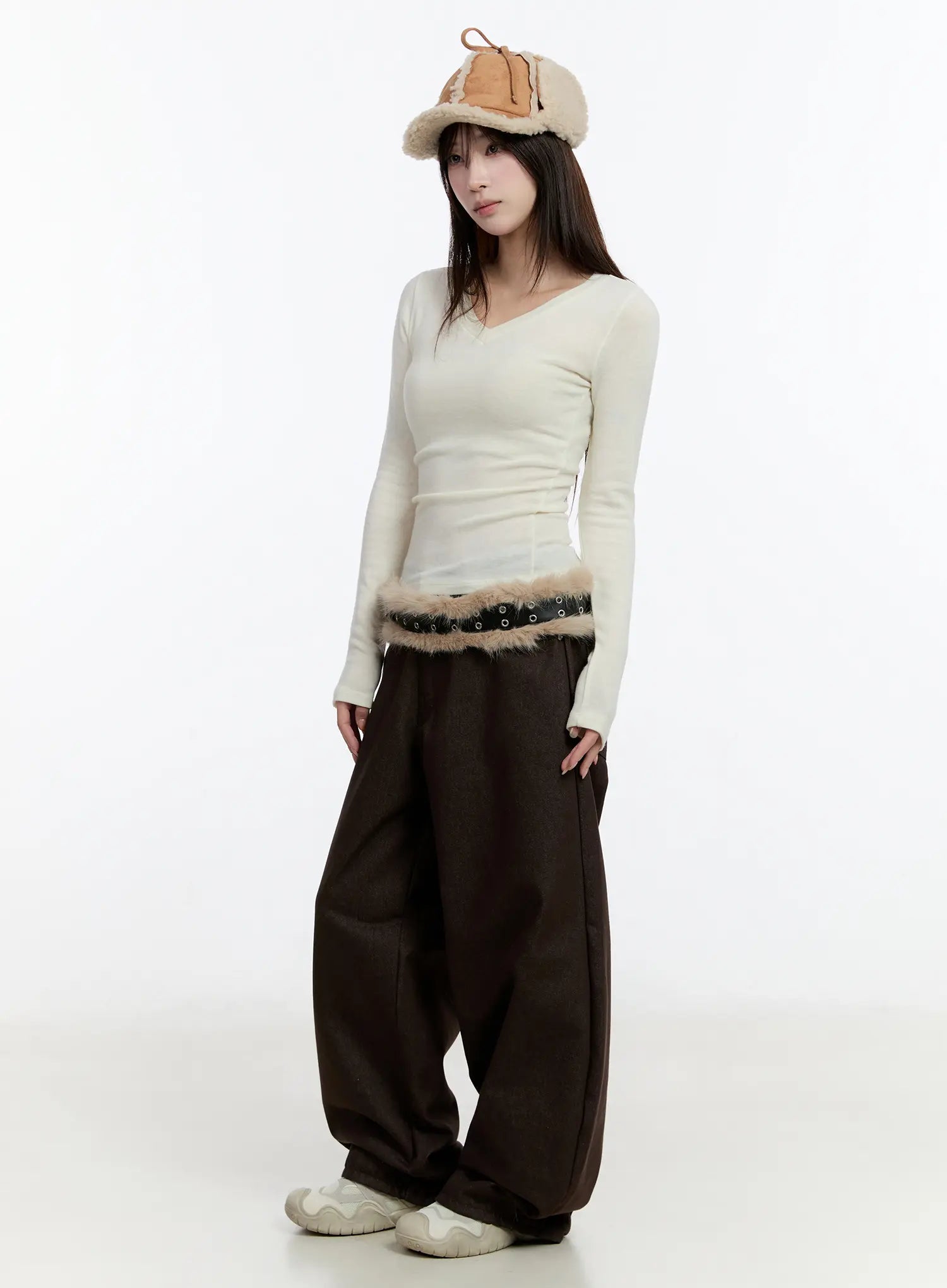 Emely Wide Leg Jeans CN524 in dark brown, three-quarter front view on model, relaxed balloon wide-leg fit, paired with cream ribbed long-sleeve top, fur-trim belt, and shearling hat.