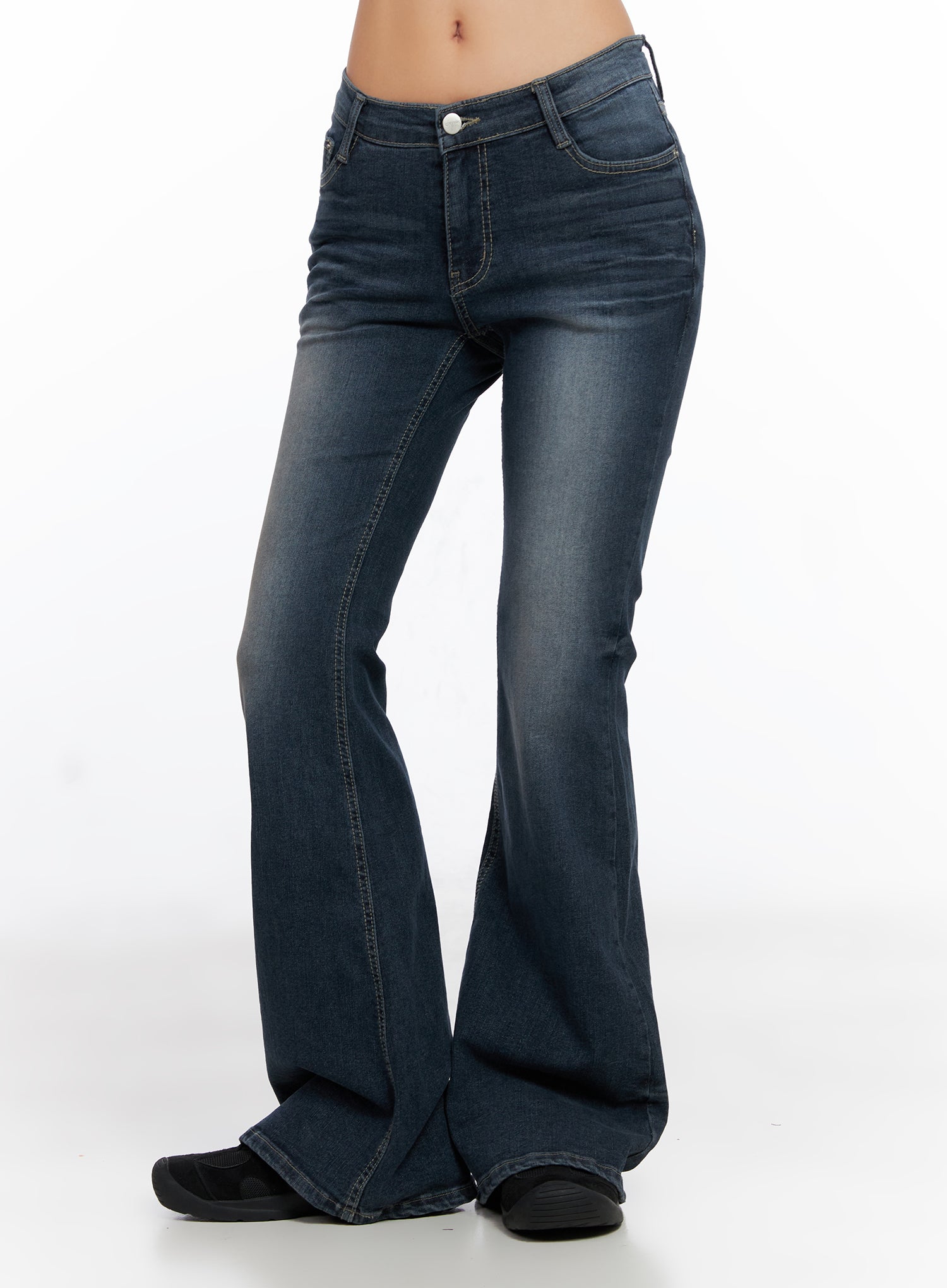 Melina Hip-Pad Low-Rise Flare Jeans CO514 in dark blue, angled front-side view on model, emphasizing low-rise waistband, slim fit through hip, and wide flare hem with contrast seam stitching.