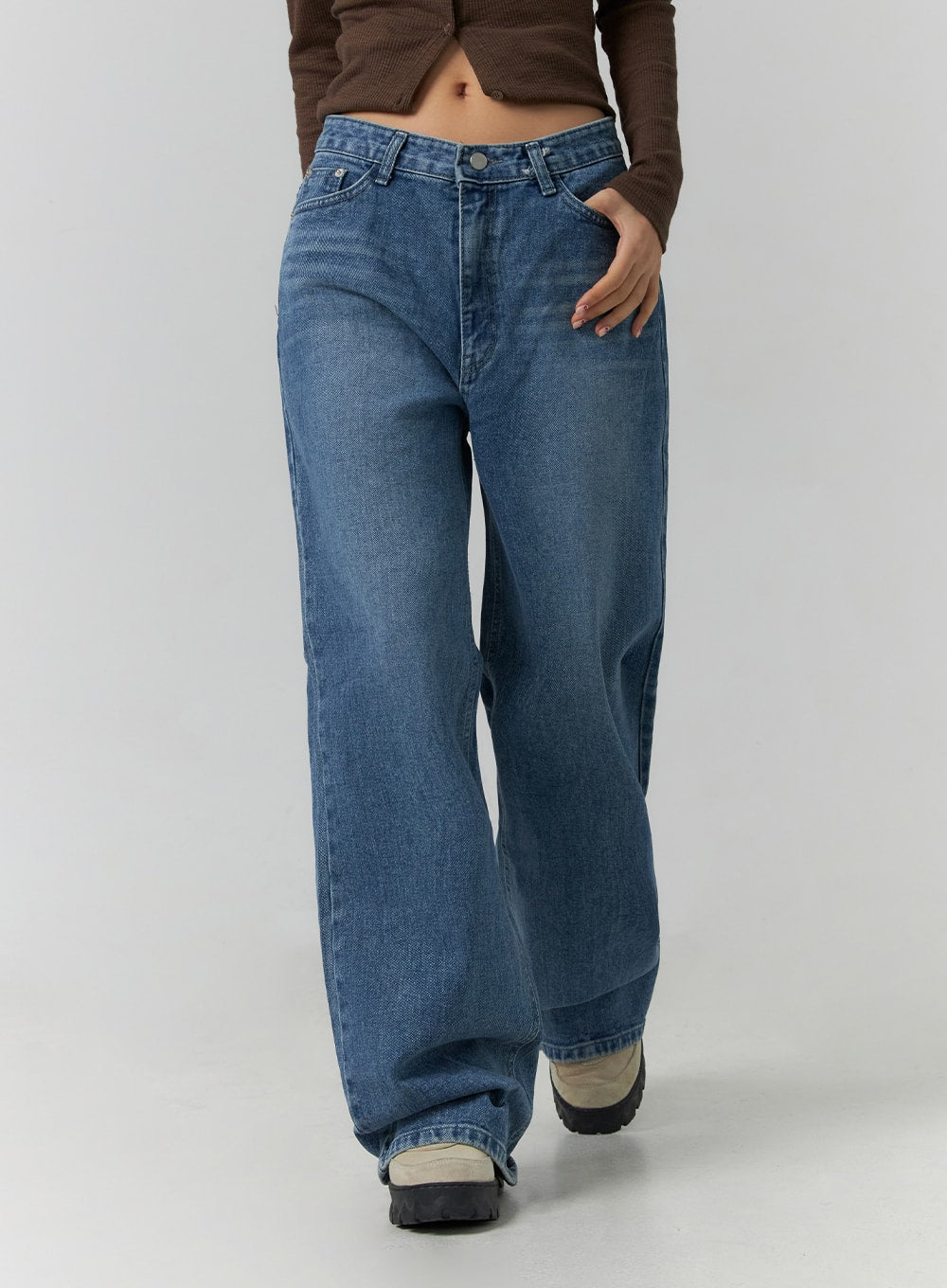 Wide Leg Jeans J12 in blue, mid-body front detail shot on model with hand in pocket, gradation-washed cotton wide-leg denim, side pocket and long floor-length leg highlighted.
