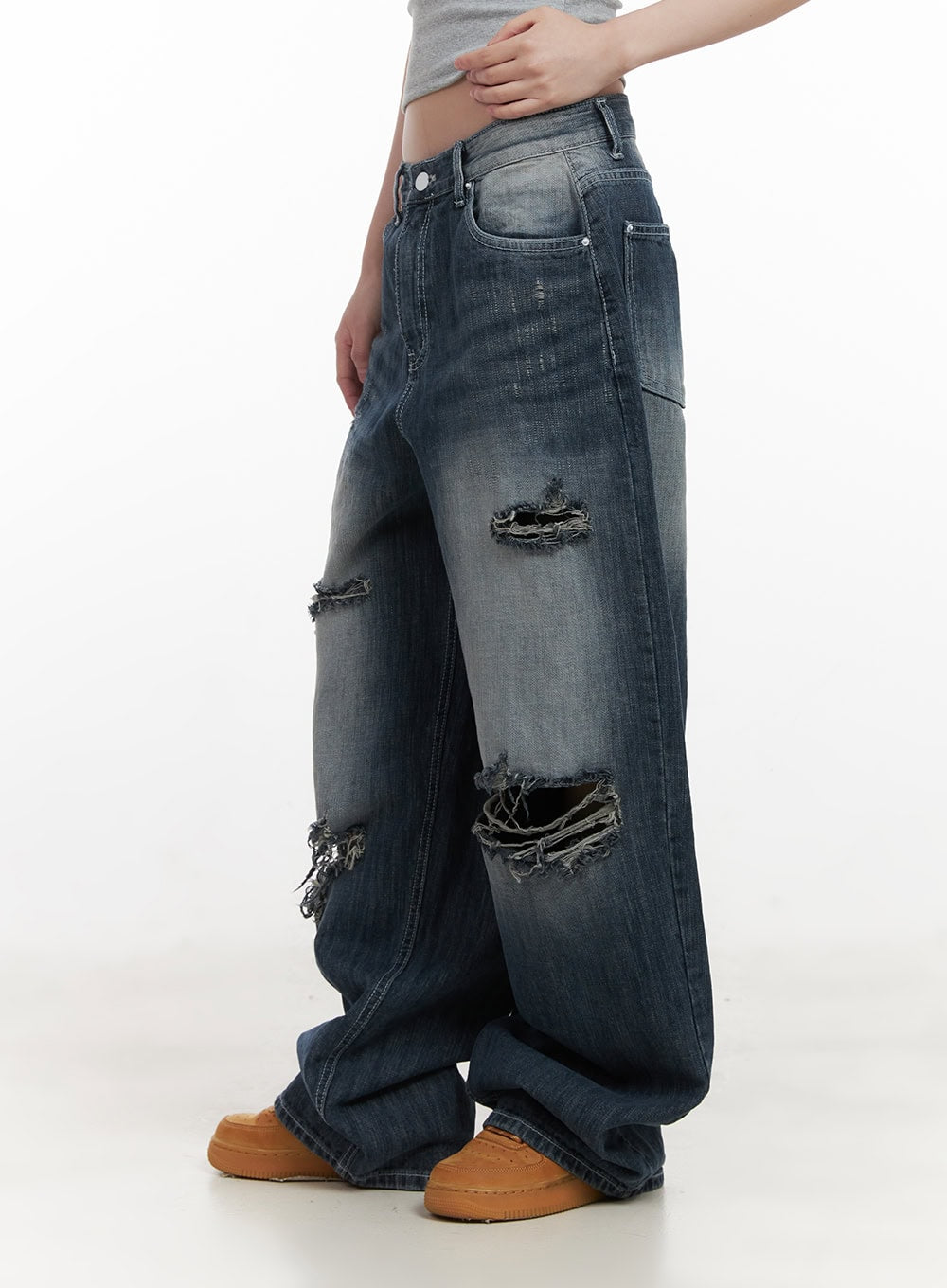 Alison Destroyed Baggy Jeans CJ523 in dark blue, side close-up on model, highlighting large frayed destroyed openings at thigh and knee with washed denim fade detail.