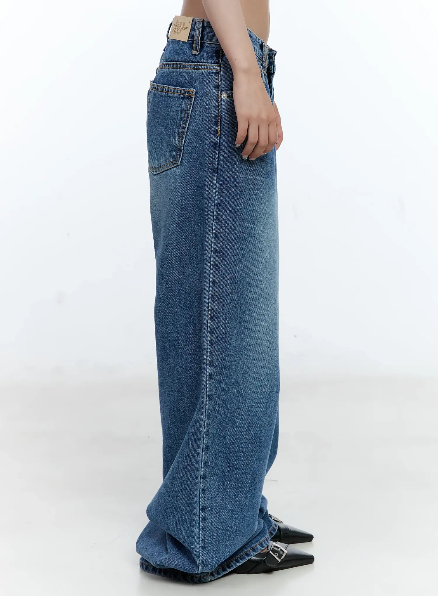 Dahye Washed Relaxed-Fit Denim Jeans CL530 in blue, close-up side view on model, back pocket and label patch visible, wide-leg relaxed cotton denim with washed texture and contrast stitching.