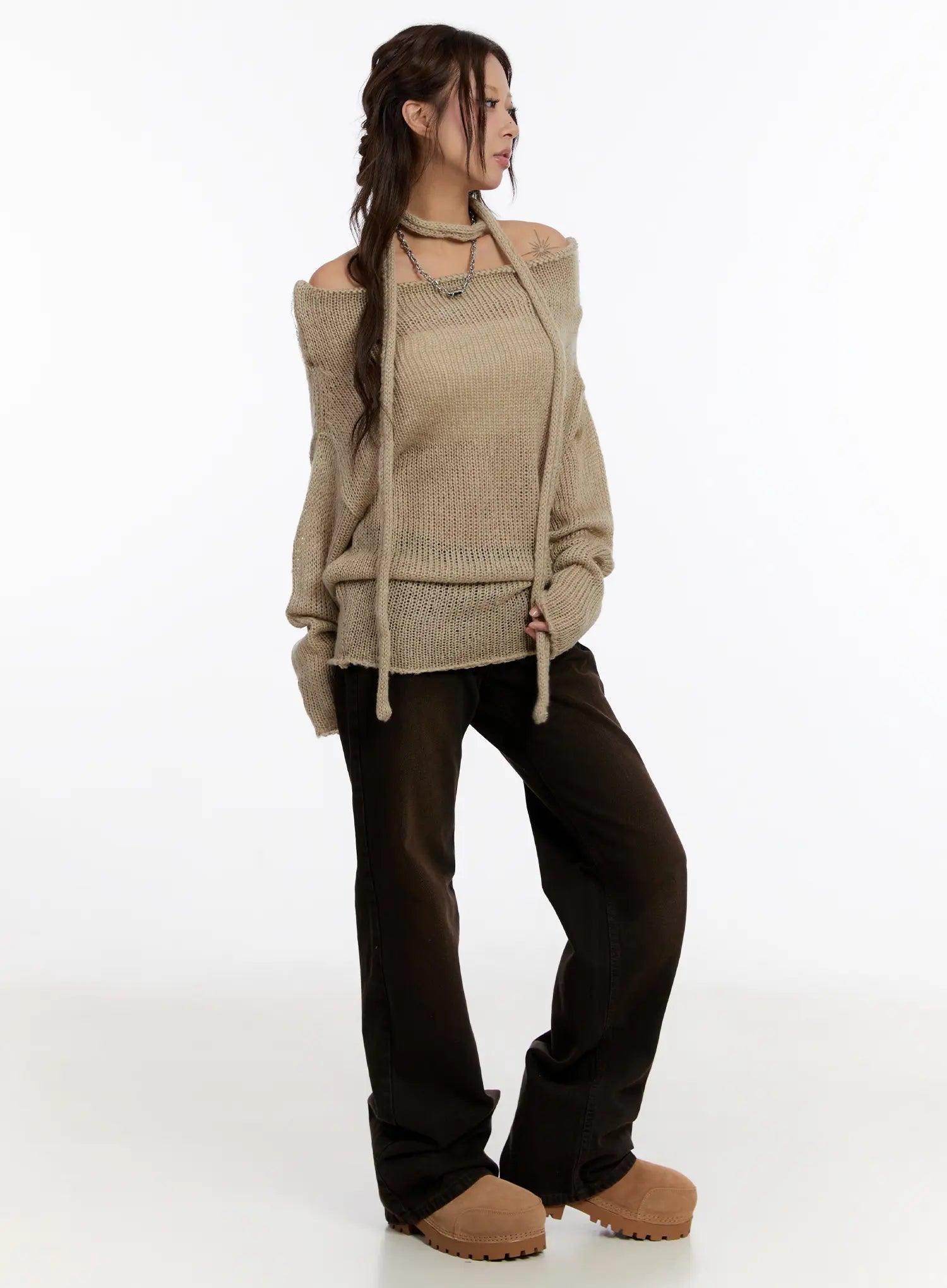 Mael Low Rise Straight Jeans CN527 in black, three-quarter front view on model, styled with oversized beige knit off-shoulder top, showing straight cotton leg and low waist.
