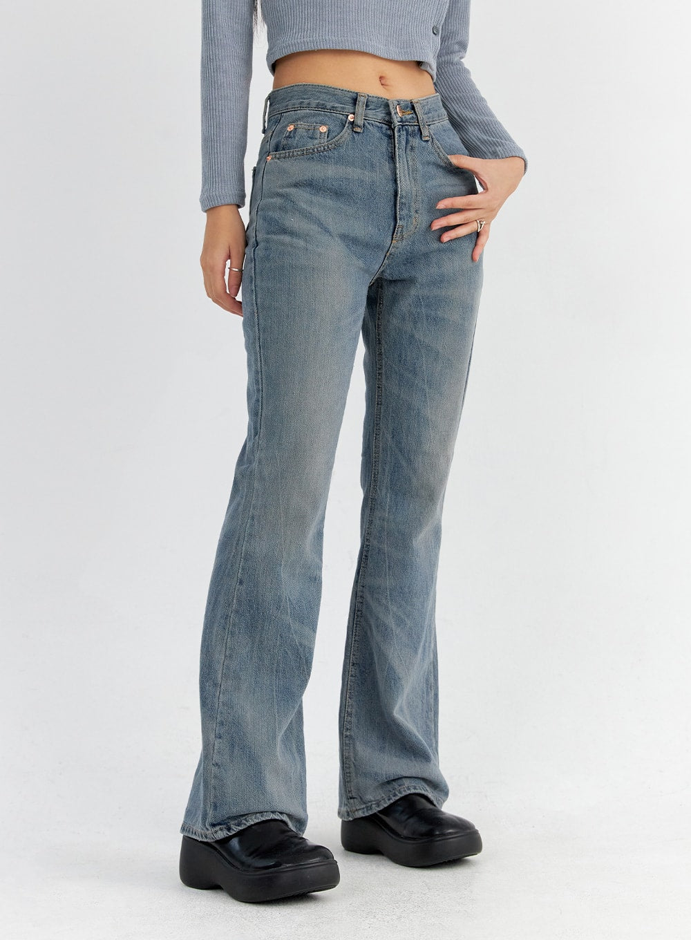 Vintage Washed Bootcut Jeans CO325 in blue, front side-angle mid-body close-up on model, slim fit high-rise waistband with five-pocket construction and washed denim texture, bootcut leg opening visible.