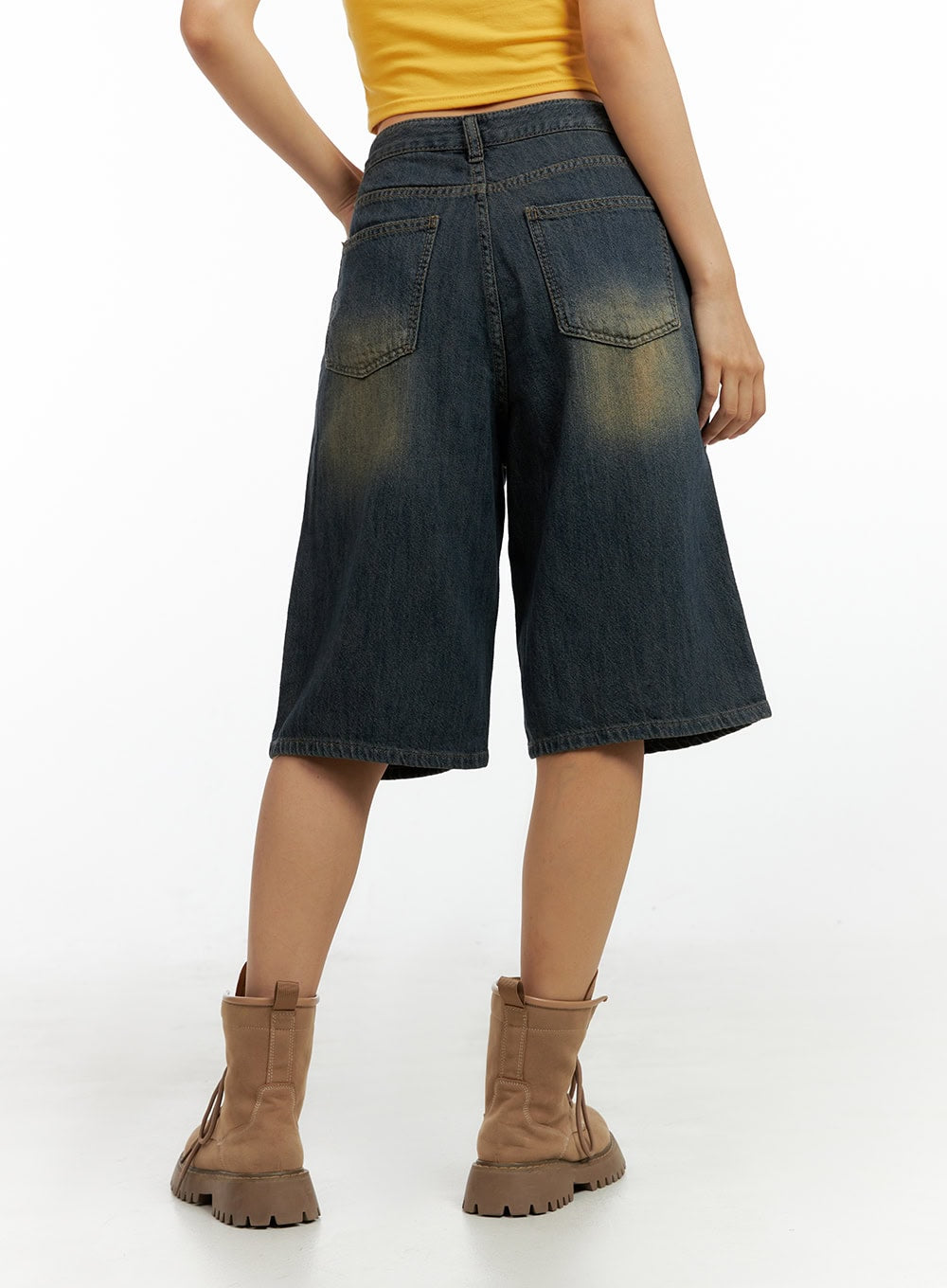 Dark Washed Wide Leg Jorts IL419 in dark blue, back view close-up showing dual patch back pockets and golden distressed wash across wide-leg denim shorts, paired with combat boots.
