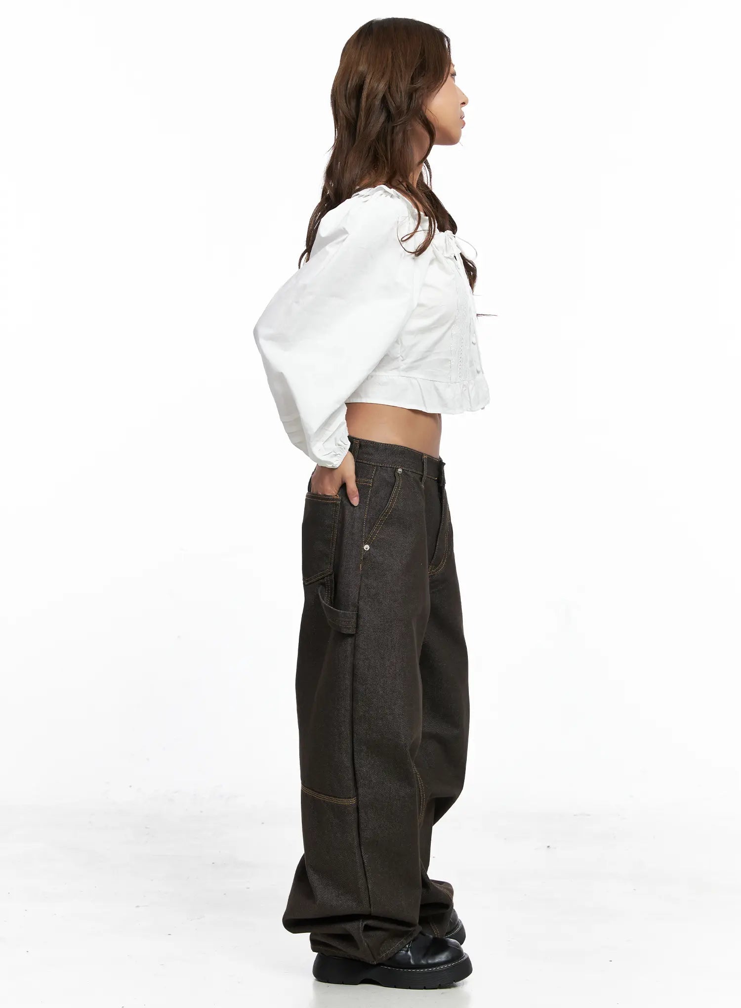 Oaklyn Non-Fade Wide-Leg Jeans CO513 in dark brown, side view full-body on model styled with white puff-sleeve crop blouse, hand in pocket, wide-leg denim pooling over black platform shoes.