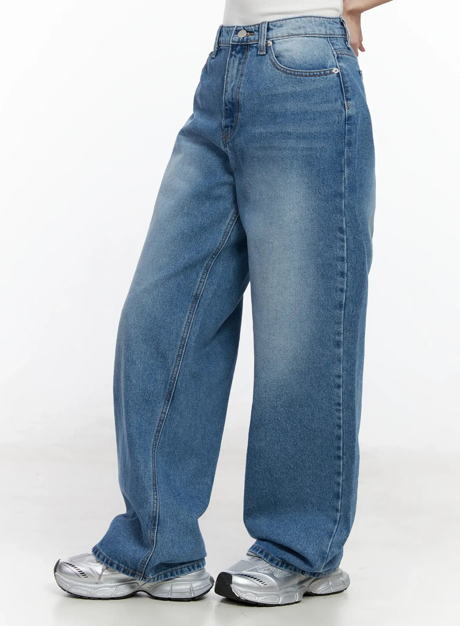 Iliana Wide Leg Jeans IJ529 in blue, rear three-quarter close-up on model, wide baggy washed cotton denim showing side seam and back pocket detail, silver sneakers.