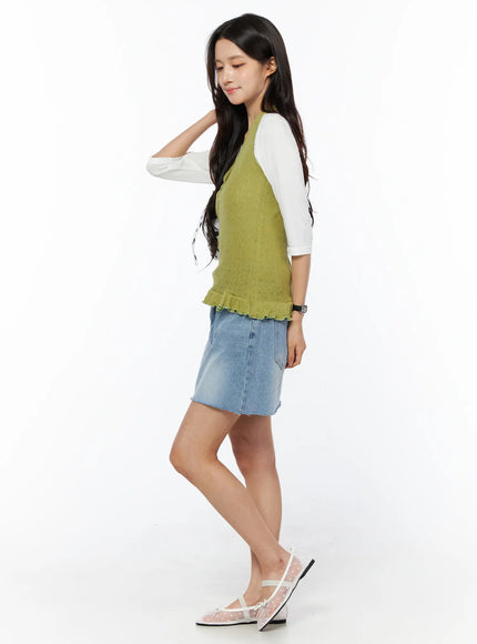 Casual Denim Mini Skirt CU522 in light blue, side full-length on model, washed denim mini length, layered under green knit vest and white tee with floral flats.